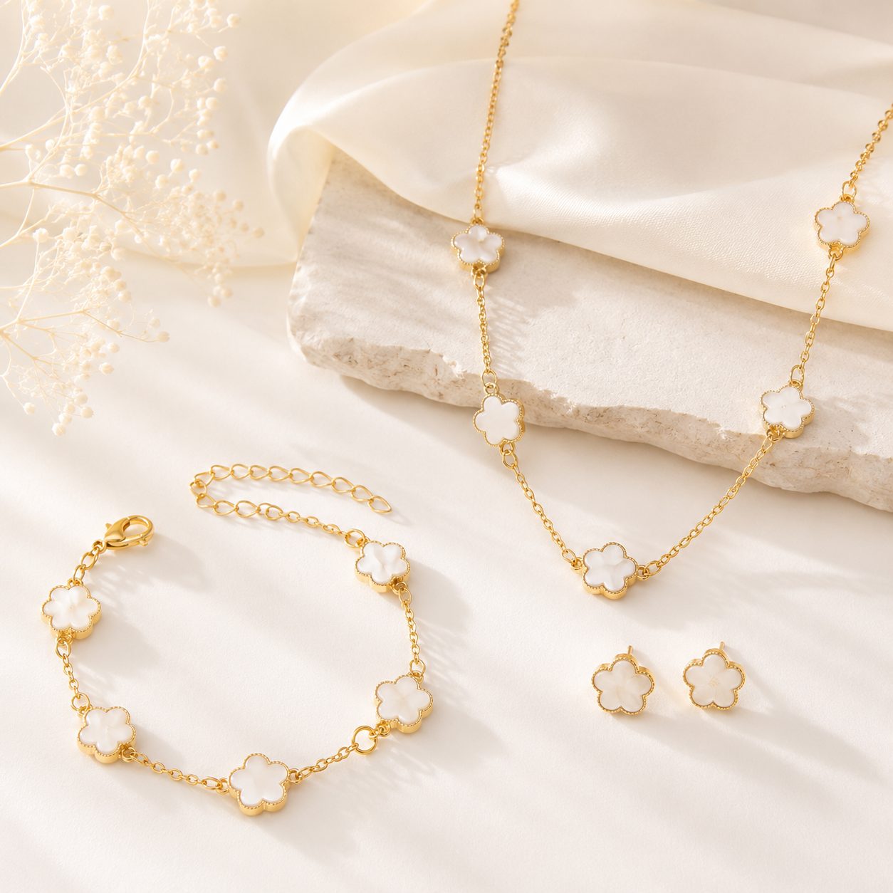 Earrings Set Gold tone clover necklace, bracelet and earrings displayed on a soft cream background for a refined everyday look
