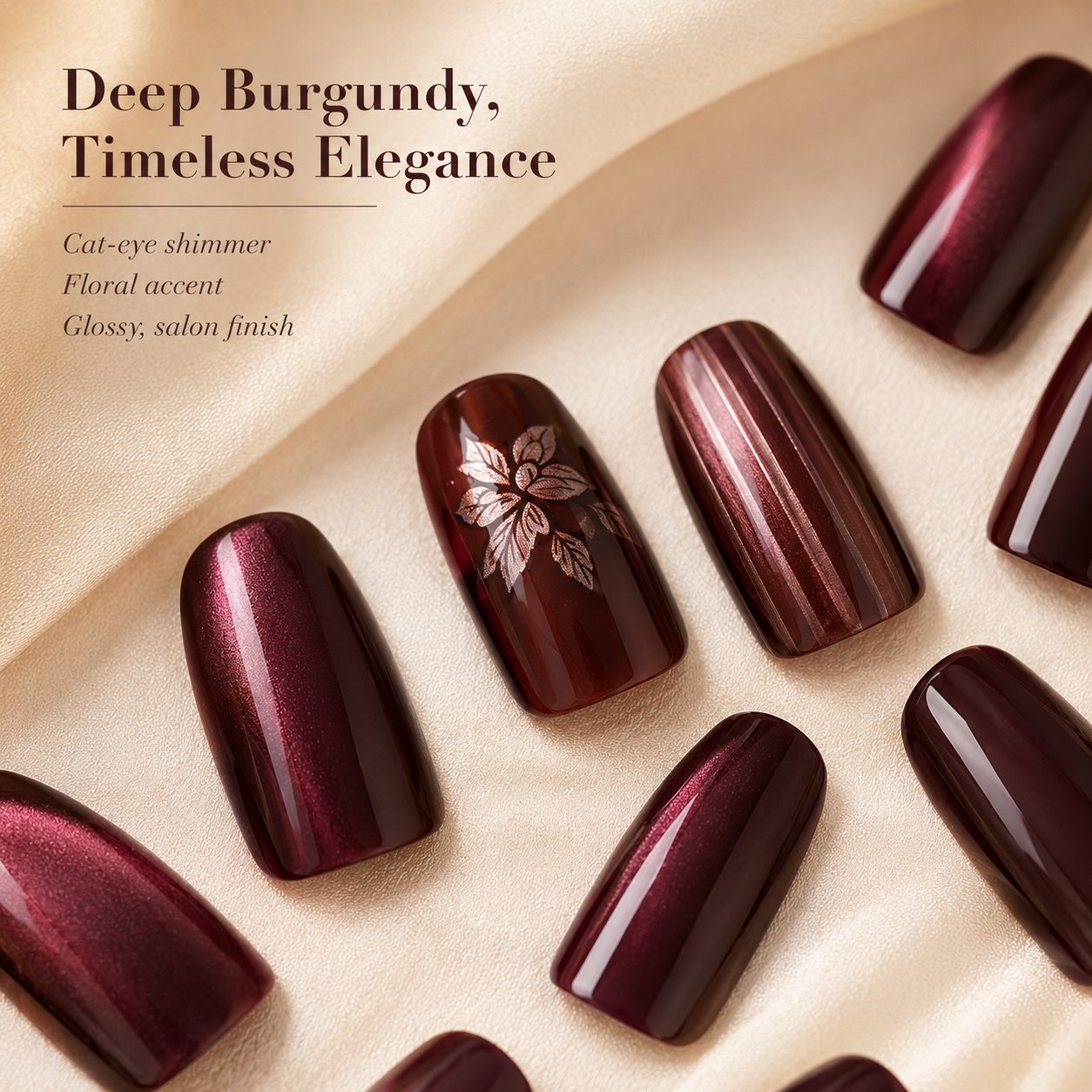 Close-up detail of deep burgundy press-on nails with cat-eye shimmer, floral accent, glossy finish, and elegant textured nail designs.