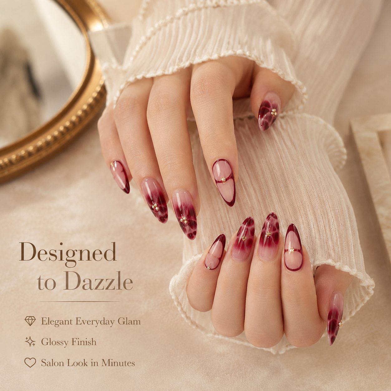 Hand close-up wearing burgundy almond press-on nails with glossy finish, deep red accents and elegant salon-inspired style