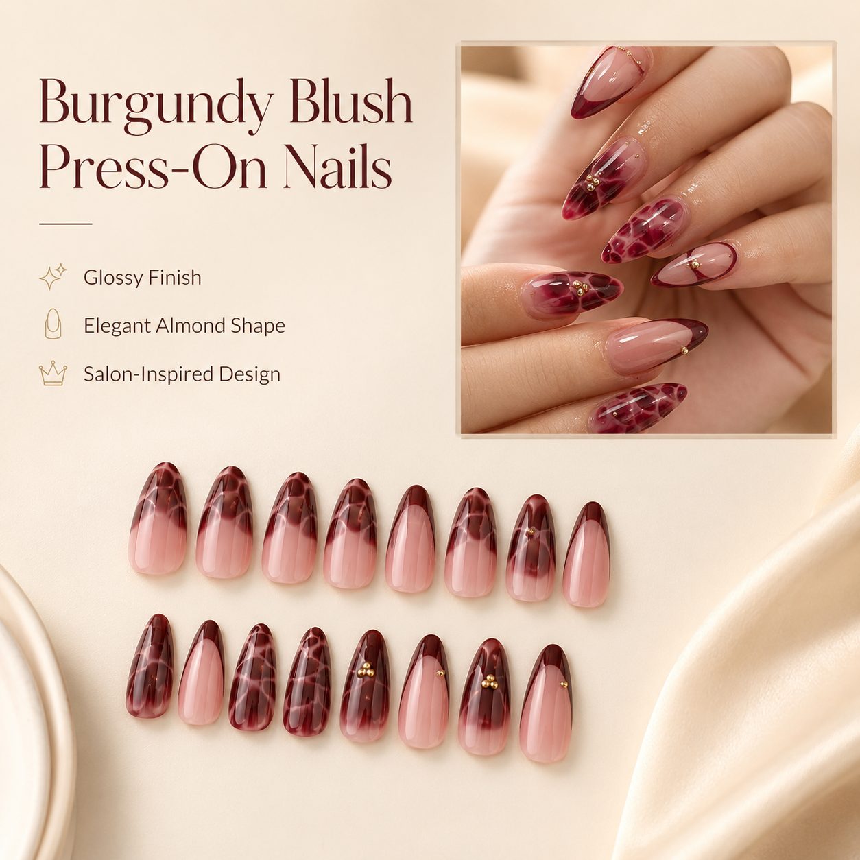 Burgundy press-on nails with glossy almond shape, soft pink base, deep red accents and delicate gold details on a light luxury background