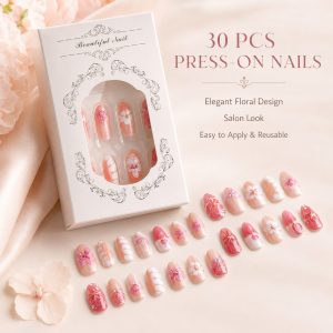 Elegant floral press-on nails displayed with a white packaging box, featuring pink, nude and coral nail tips with flower, butterfly and glossy salon-style designs.