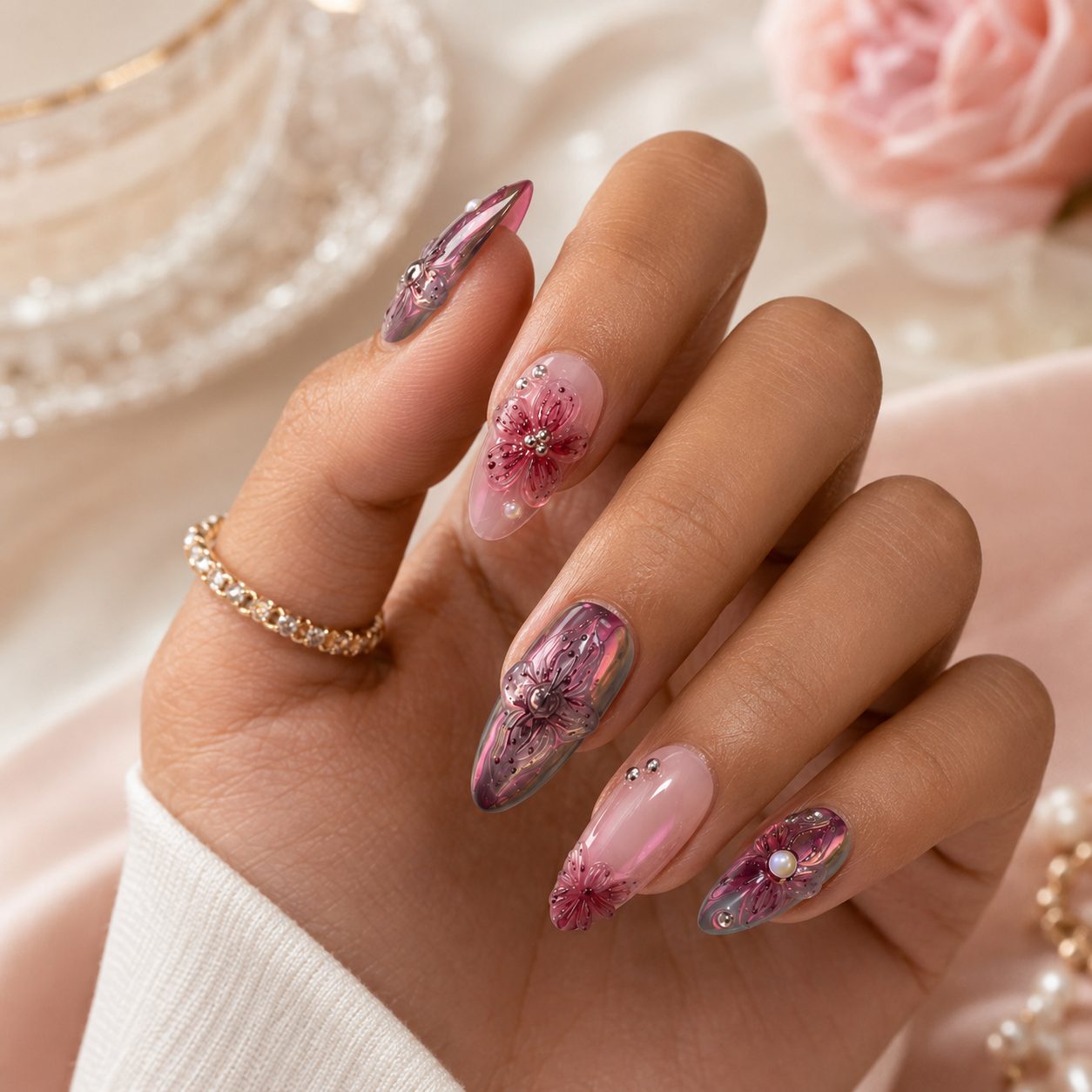 Medium tan hand wearing elegant 3D floral press on nails in pink burgundy tones with glossy gem accents.