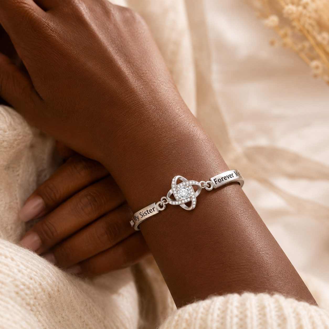 Deep skin tone wrist wearing silver To My Sister bracelet with CZ center and engraved Forever My Sister design