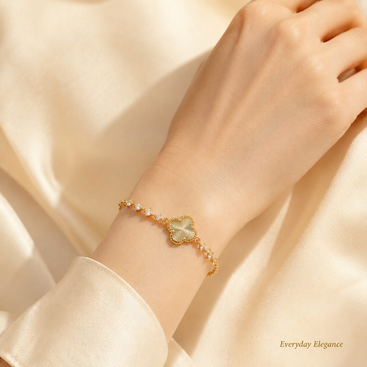 Gold lucky clover bracelet worn on wrist with black stone accents in an elegant hand close up